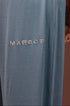 Close-up of a person wearing slate blue ribbed lounge pants with the brand name &